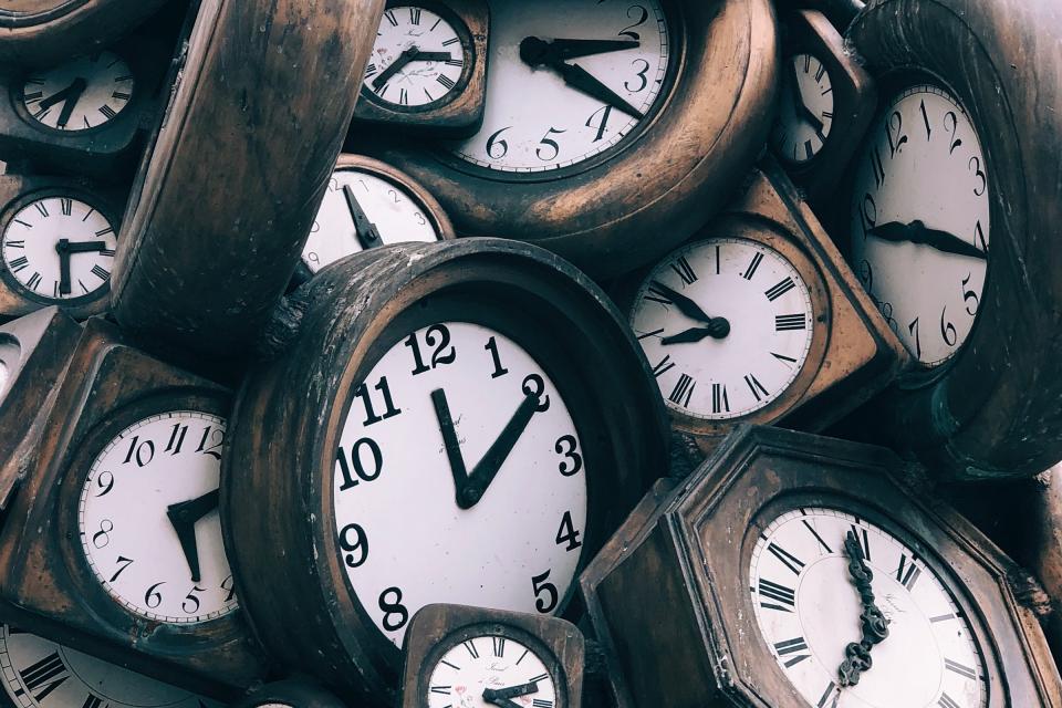 A pile of wooden analog clocks.