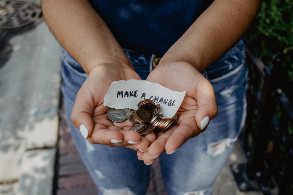 Fundraising. Hands holding change and a note.